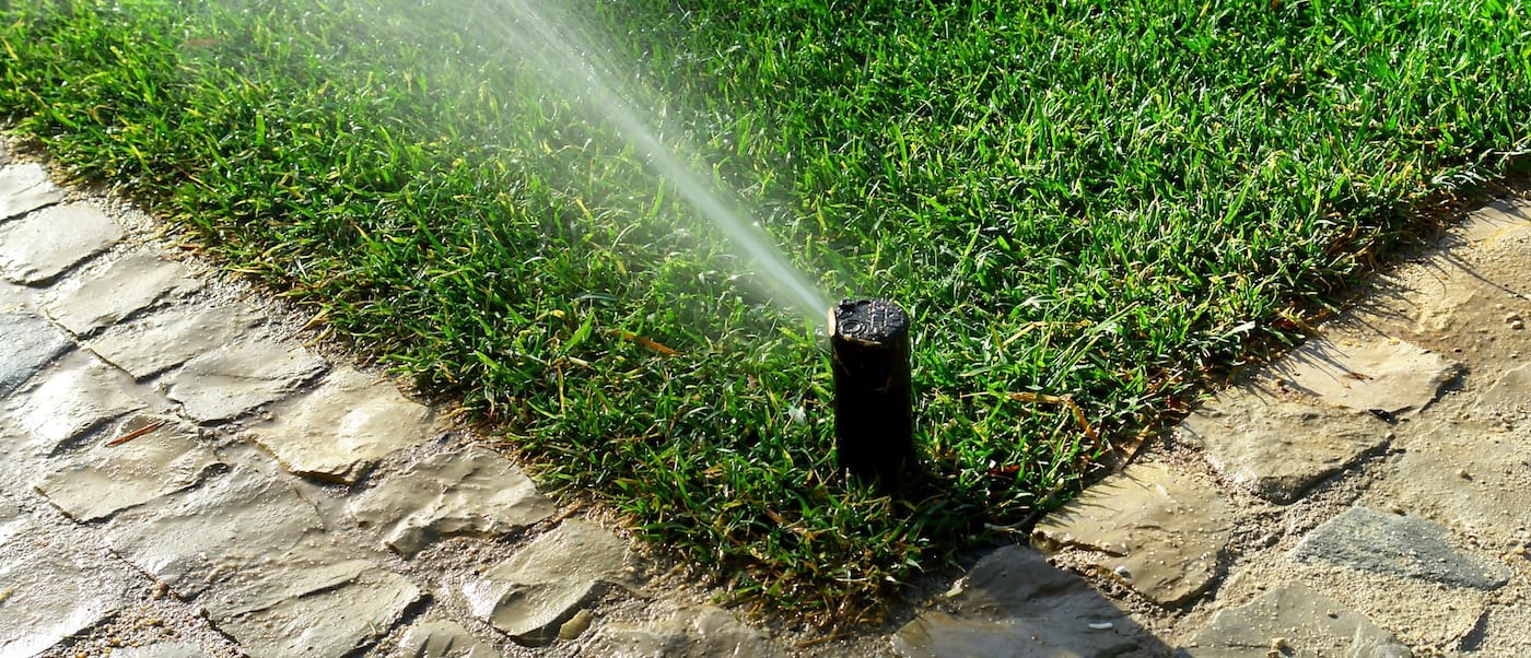 Irrigation watering a striped lawn